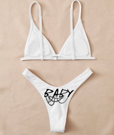 White bikini set with 'BABY' and chain design on beige background