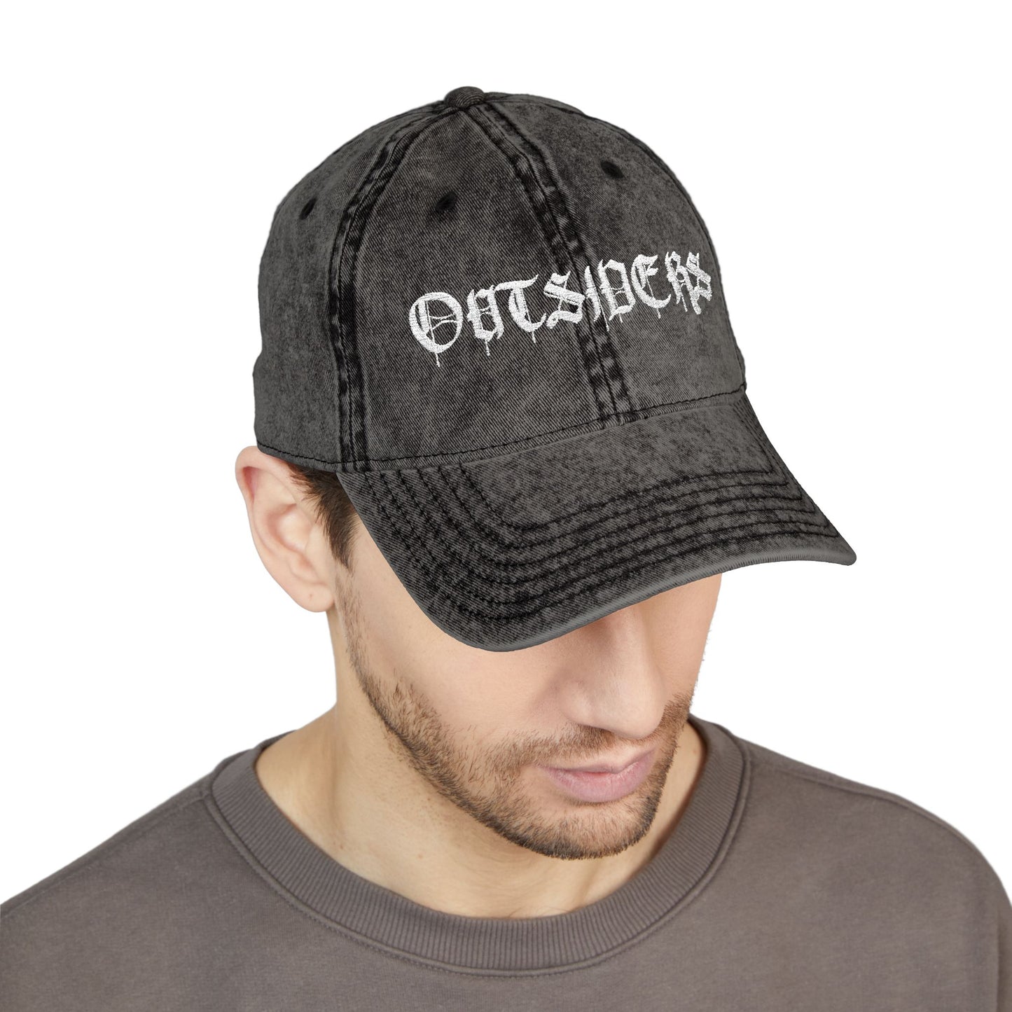 Man wearing a black denim cap with 'OUTSIDERS' text on a white background