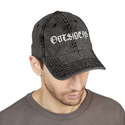 Man wearing a black denim cap with 'OUTSIDERS' text on a white background