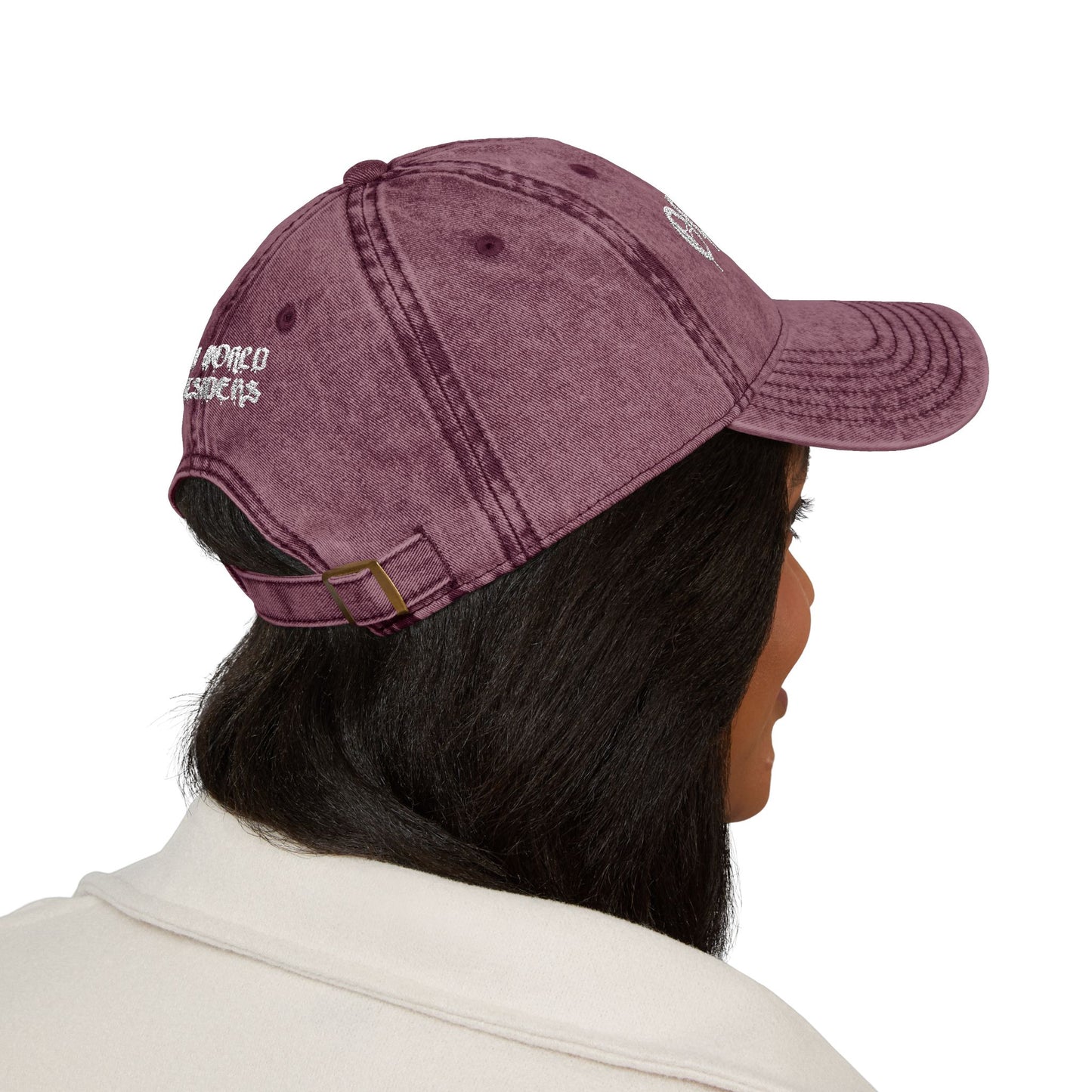 Person wearing a maroon cap with a logo on a white background
