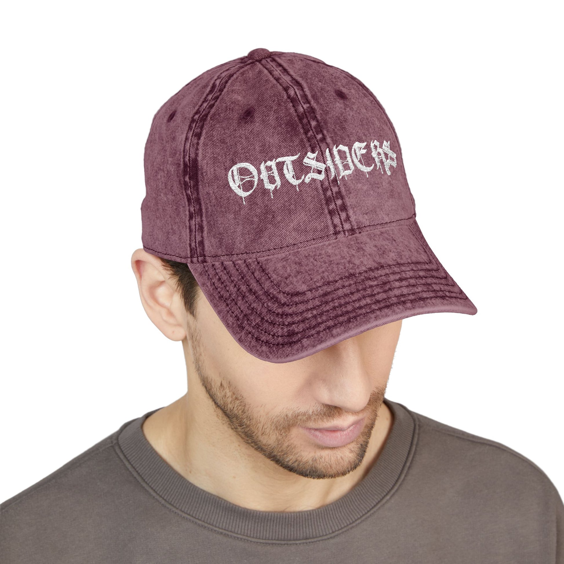 Man wearing a maroon cap with 'OUTSIDERS' text on a white background