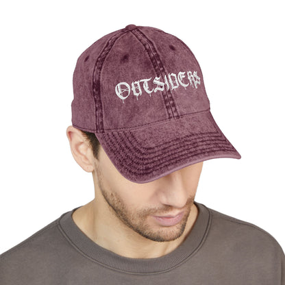 Man wearing a maroon cap with 'OUTSIDERS' text on a white background