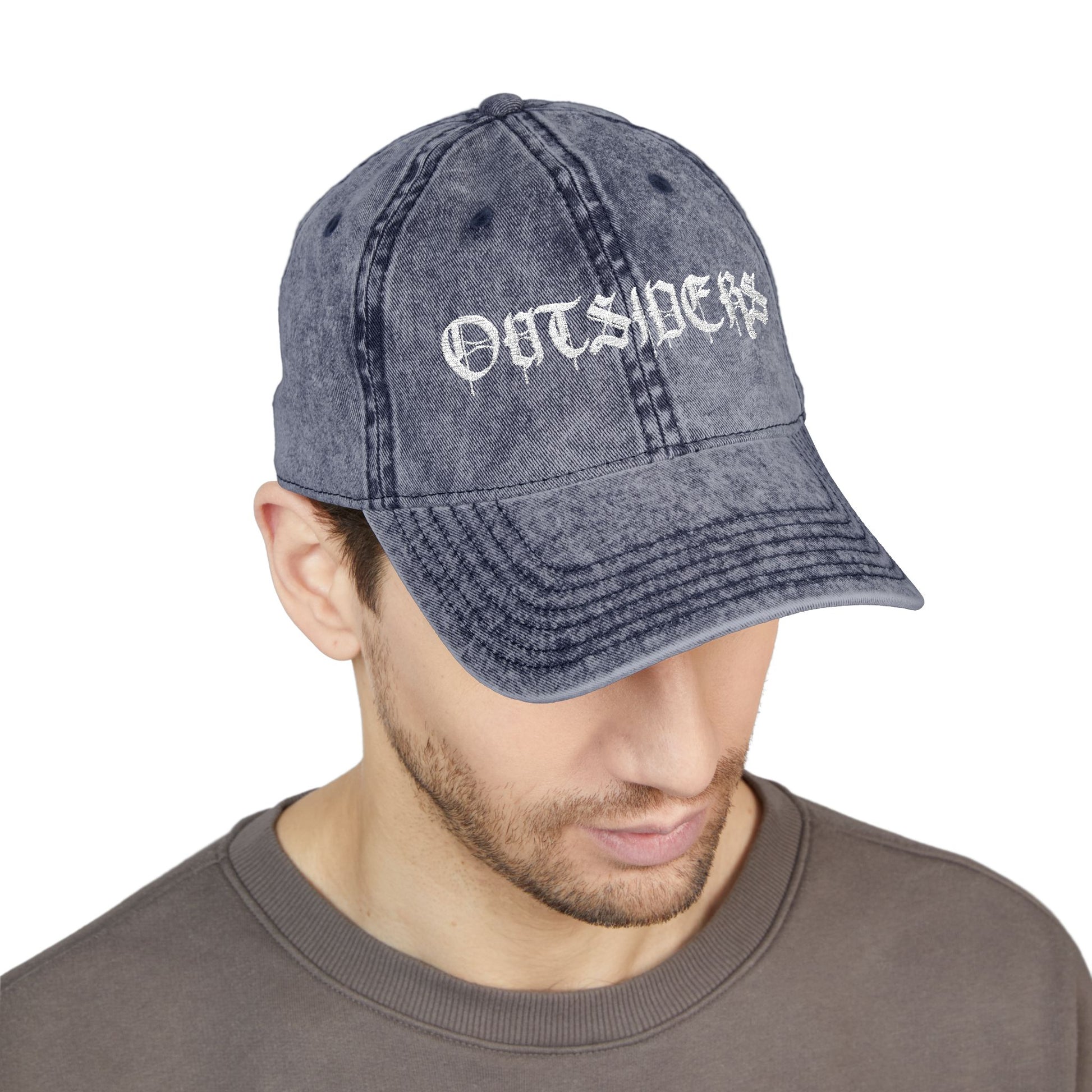 Man wearing a denim cap with 'OUTSIDERS' text on a white background