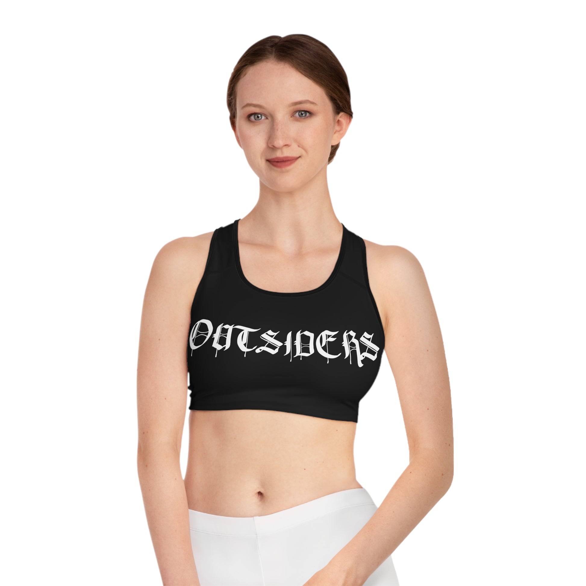 Woman wearing a black sports bra with 'OUTSIDERS' text on a white background