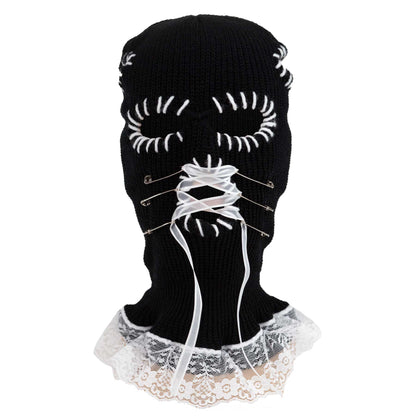 Black knit balaclava with white lace details on a white background