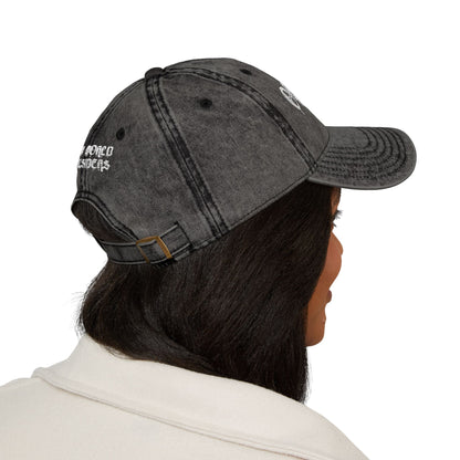 Person wearing a gray denim cap with text on a white background
