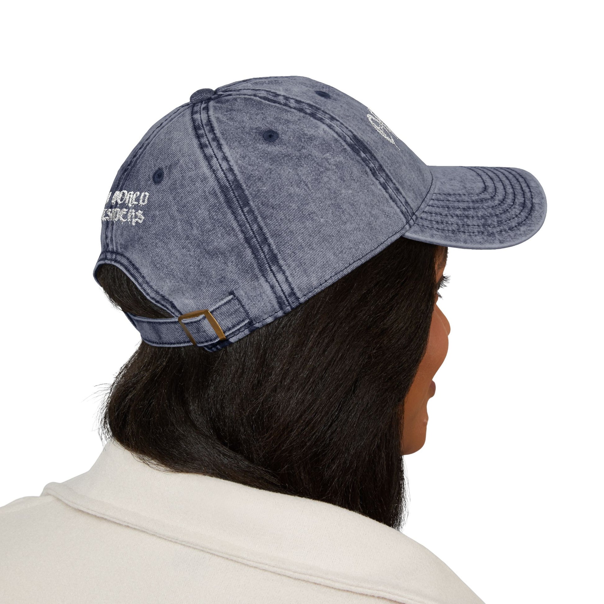 Person wearing a denim cap with a brand logo on a white background