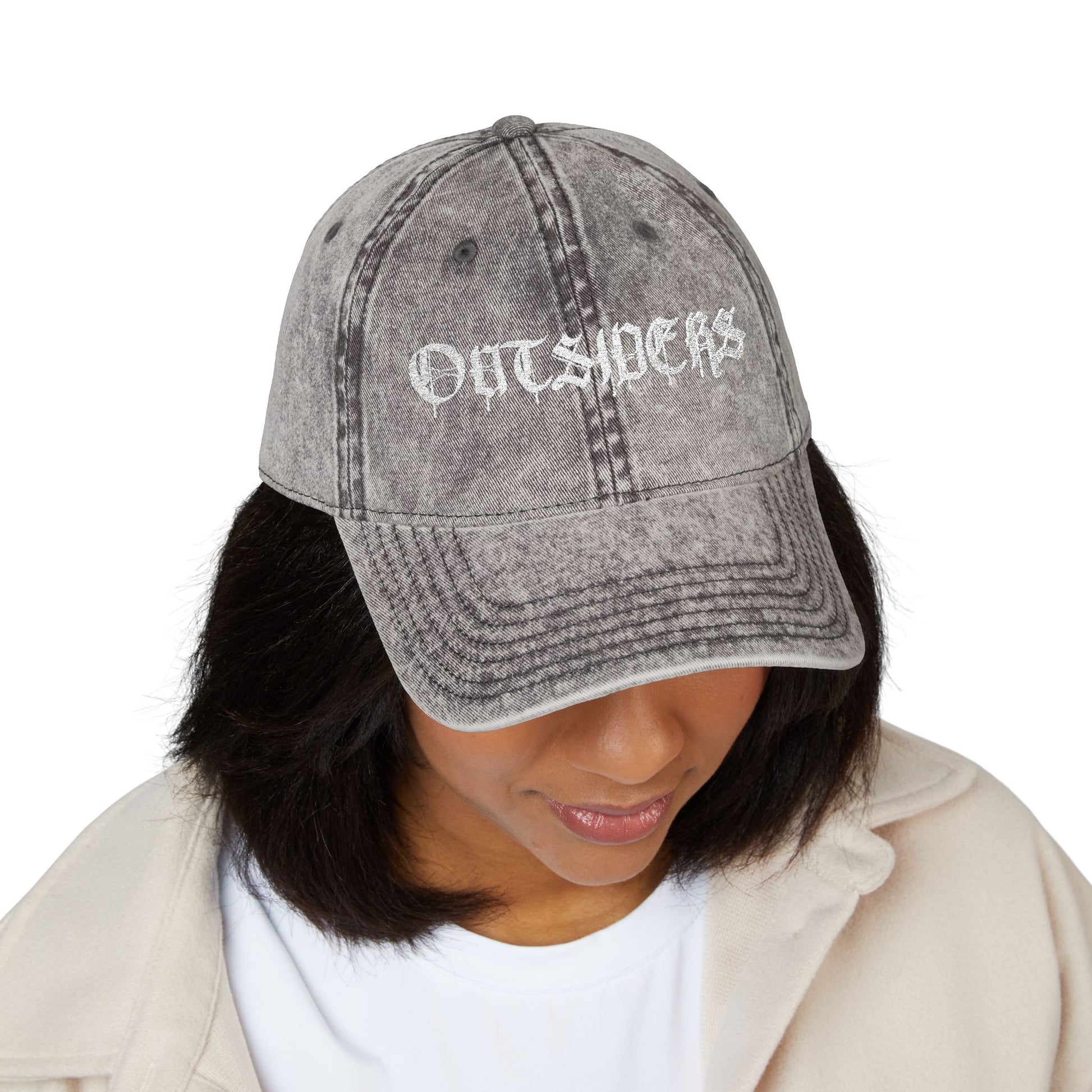 Person wearing a gray distressed baseball cap with 'OUTSIDERS' text on a white background