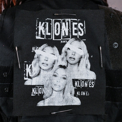Black jacket with 'KLONES' screen print patch design safety pinned to the back of vest 