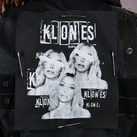 Black jacket with 'KLONES' screen print patch design safety pinned to the back of vest 