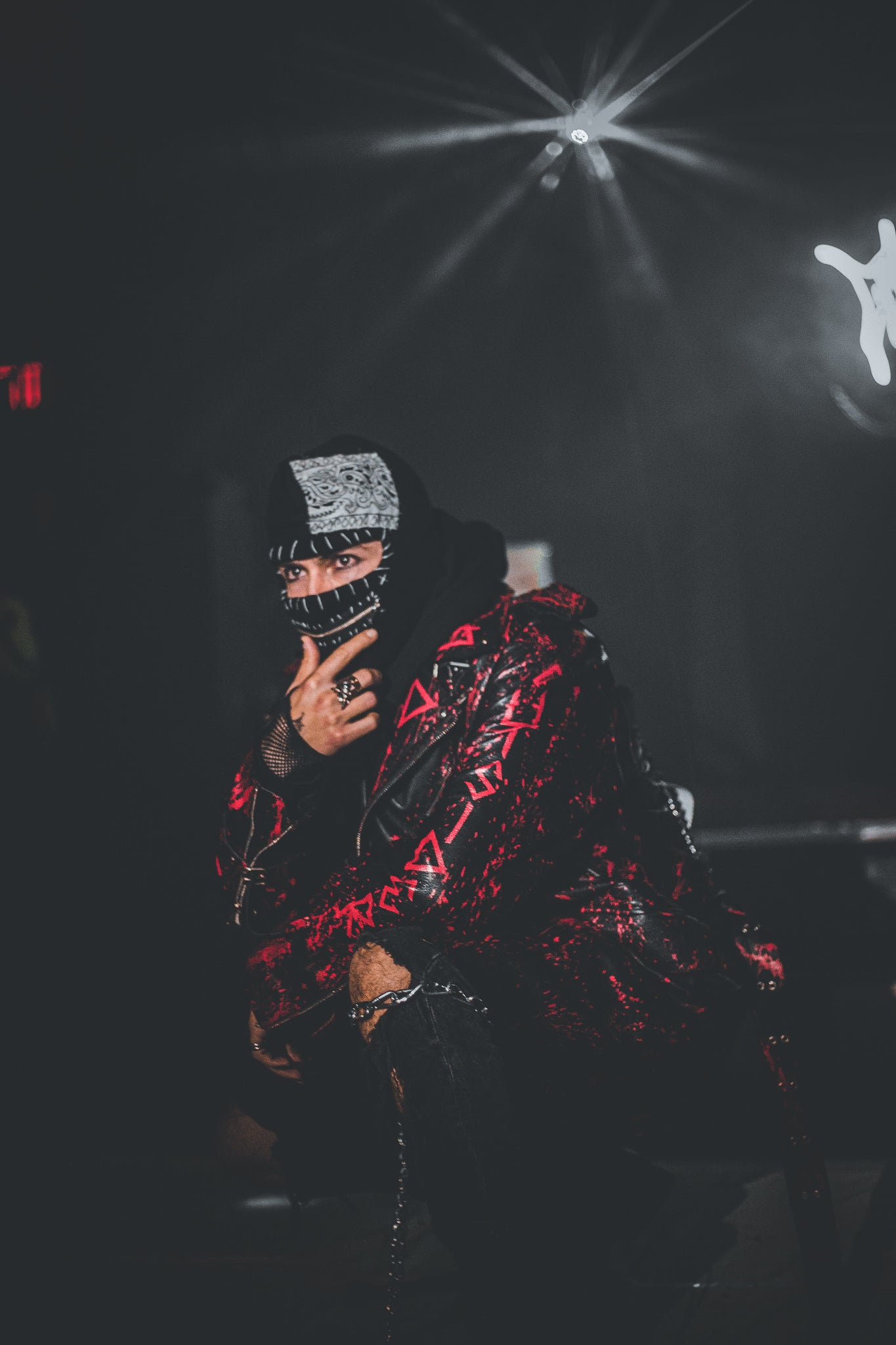 Person wearing a red and black jacket with a dark background