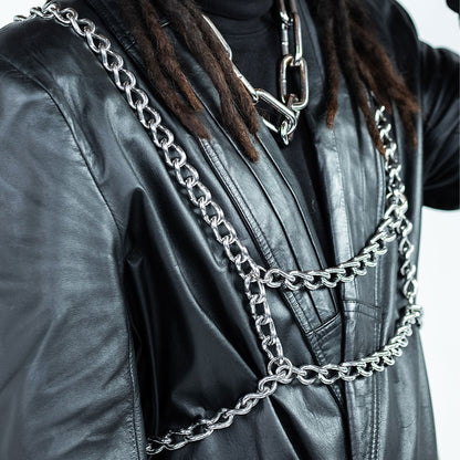 Person wearing a black leather jacket with silver chain details