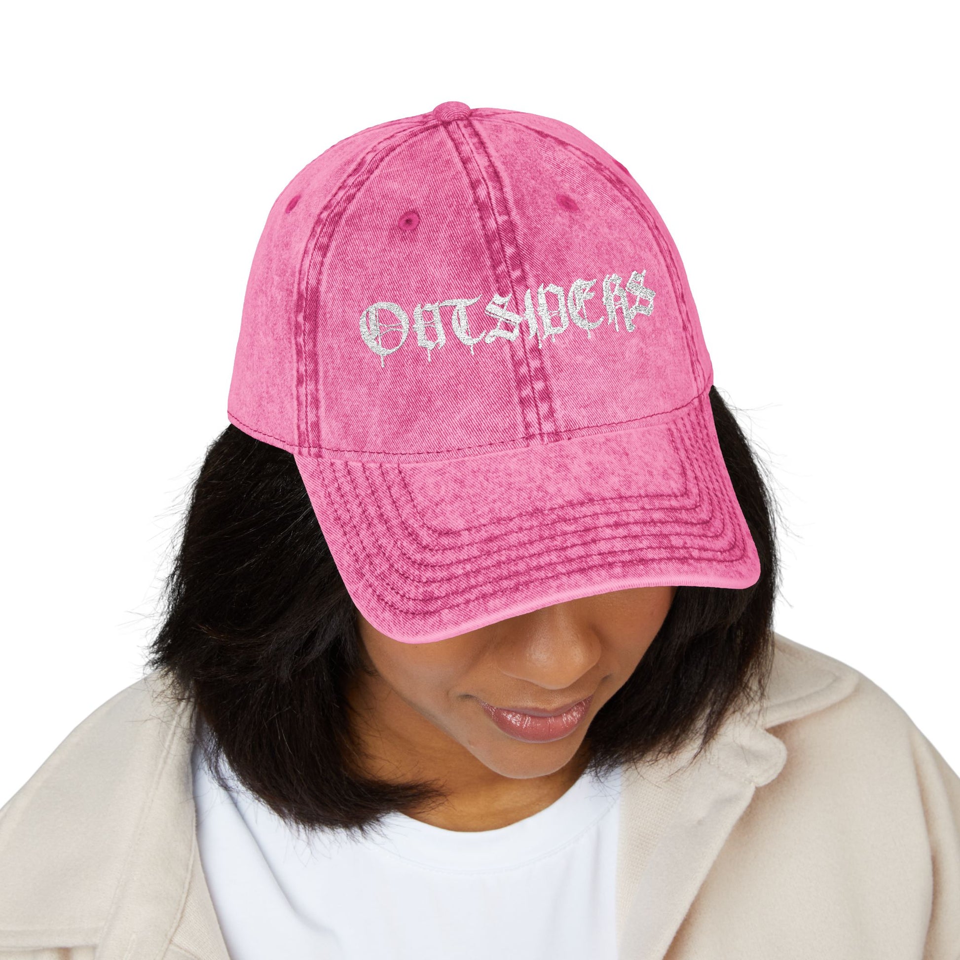 Person wearing a pink cap with 'OUTSIDERS' text on a white background