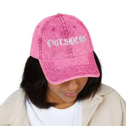 Person wearing a pink cap with 'OUTSIDERS' text on a white background
